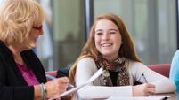 iStock_526640507.jpg Teacher helping preteen students with homework during tutoring session