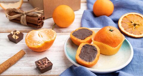 iStock-1386918267_SugarFree_1.jpg Truffle chocolate tangerine candies on a white wooden background. Side view.