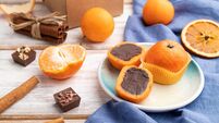 Truffle chocolate tangerine candies on a white wooden background. Side view.