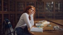 CAO4_iStock-2147679405.jpg Bored redhead student thinking in library.
