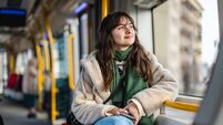 iStock-2207179761.jpg Young woman looking out of the tram window