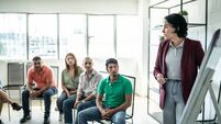 iStock-1438224838.jpg Mid adult woman doing a presentation during a meeting
