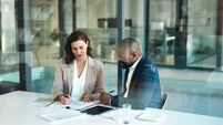Buyouts - iStock-1502896527.jpg Office, meeting and documents of business people, clients or team for taxes, audit or revenue report in accounting. Paperwork, r