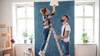 Mid adults couple changing light bulb indoors at home, relocation and diy concept.