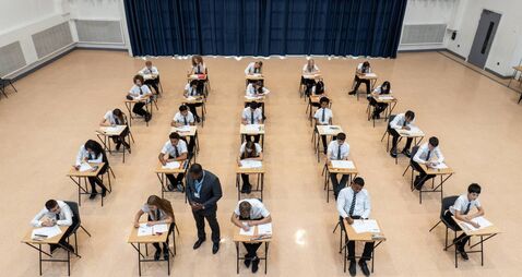 GettyImages-2237937200.jpg One male teacher checking on rows of teenage students taking a school exam shot from a high angle perspective, Newcastle upon Ty