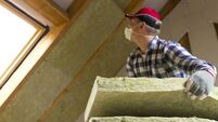 iStock-873936804.jpeg Man installing thermal roof insulation layer - using mineral wool panels. Attic renovation and insulation concept