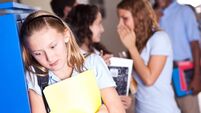 Insecure teenager at school with girls gossiping