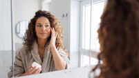 Mid adult woman applying skincare cream in the bathroom