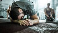 Exhausted male athlete feeling tired after sports class in a gym.