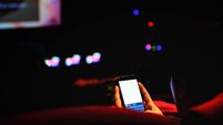 Man use mobile phone and blurred image off light in the theater, See a movie at the cinema do not use the phone. disturbing in c