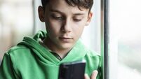 Boy with smartphone indoors. Preteen boy using a phone checking social media. Concept of children using the smartphone