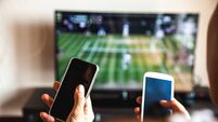 Friends using mobile phone during a tennis match