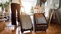Unrecognizable couple arriving at the accommodation with their suitcases